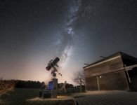 Eine magische Szenerie!  Hoch am Himmel prangt auff&auml;llig das majest&auml;tische Band der Milchstra&szlig;e. Mit dem Teleskop im Vordergrund wird ein kleiner Teil dieser kosmischen Pracht eingefangen und so f&uuml;r jedermann zug&auml;nglich! 