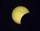 Wie aus einer surrealen Welt! Der D&uuml;senjet schie&szlig;t wie aus dem Nichts aus der abgedunkelten Mondscheibe heraus geradewegs der angeknabberten hellen Sonne entgegen. Partielle Sonnenfinsternis 12. August 2026
