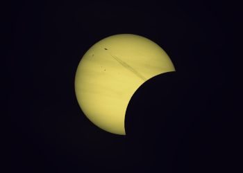 Wie aus einer surrealen Welt! Der D&uuml;senjet schie&szlig;t wie aus dem Nichts aus der abgedunkelten Mondscheibe heraus geradewegs der angeknabberten hellen Sonne entgegen. Partielle Sonnenfinsternis 12. August 2026